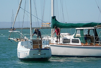 A neighbor fends off a derelict boat in La Paz, BCS, Mexico