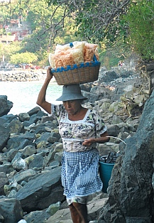 Vendors hike the rocks from La Ropa Beach to Las Gatas Beach, Zihuatanejo, Mexico.
