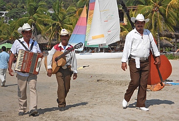 Mariachi musicians walk Playa La Ropa, Zihuatanejo, Mexico.