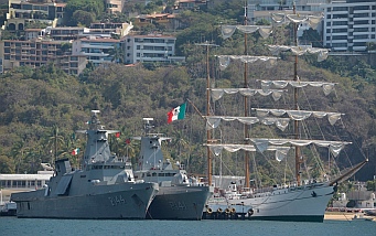 Navy warships and a tall ship in Acapulco Bay.