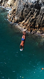 Cliff diver plunges into the water at La Quebrada.